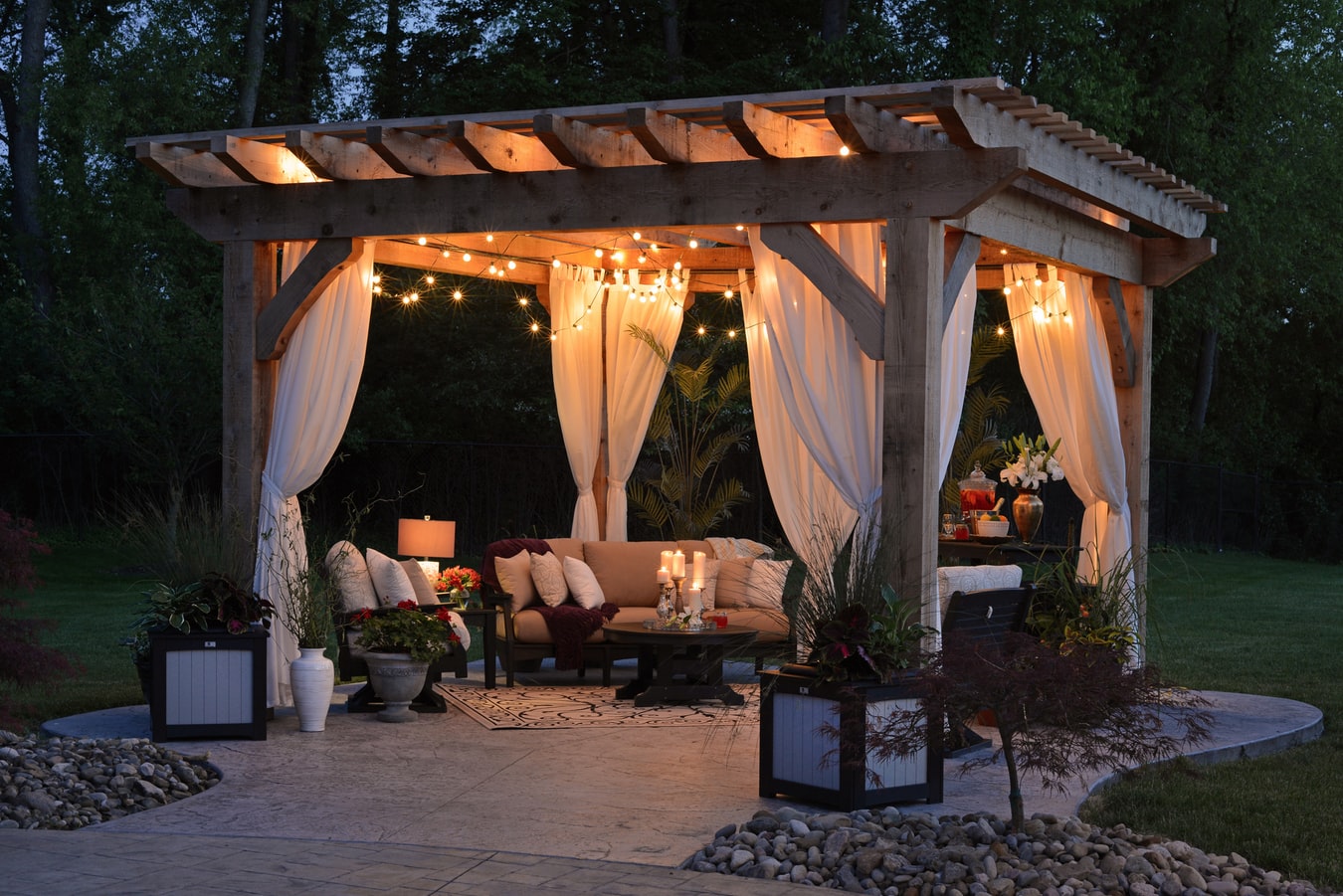Wooden pergola with curtains and lights